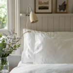 Aurelia sateen duvet cover set in ivory on a made bed with matching pillow shams