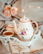 Camellia fine porcelain teapot with floral detail and a cup of tea on a white tray