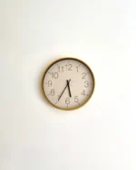 Halo minimal wall clock with a slim gold-tone rim and white dial on a clean white wall