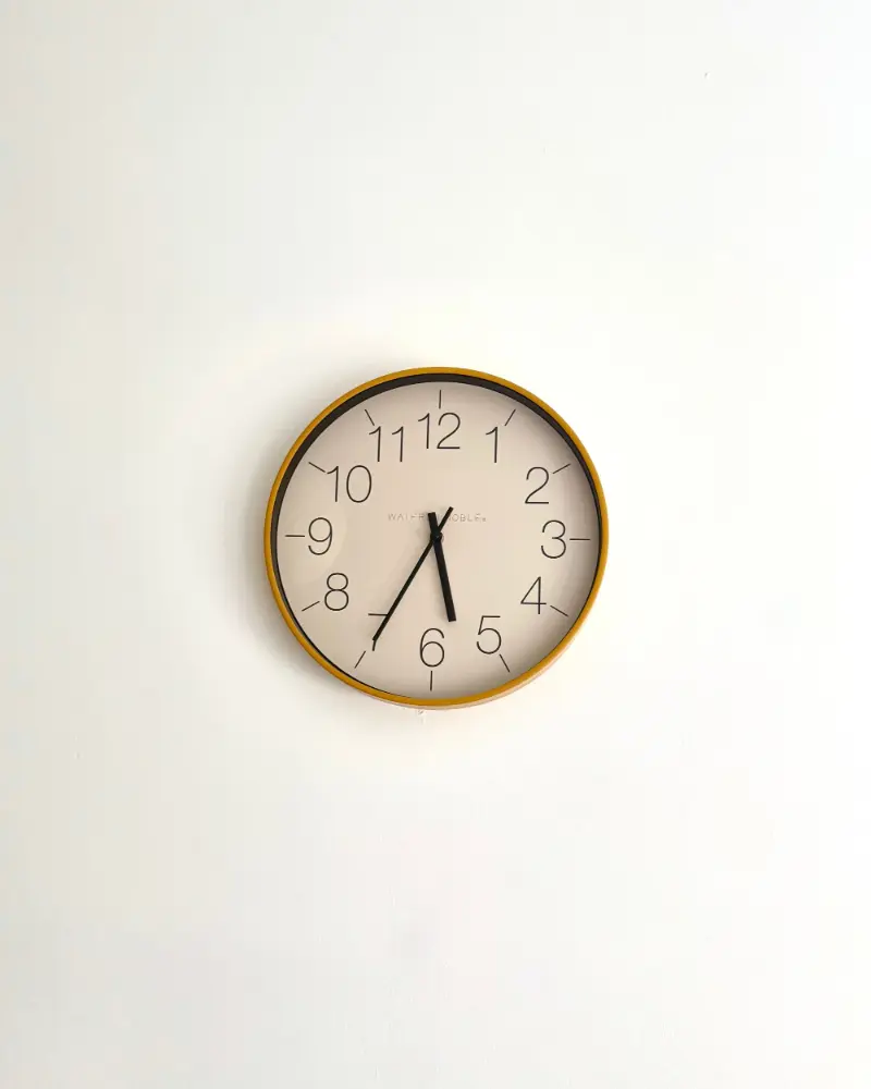 Halo minimal wall clock on a white wall Halo minimal wall clock with a slim gold-tone rim and white dial on a clean white wall