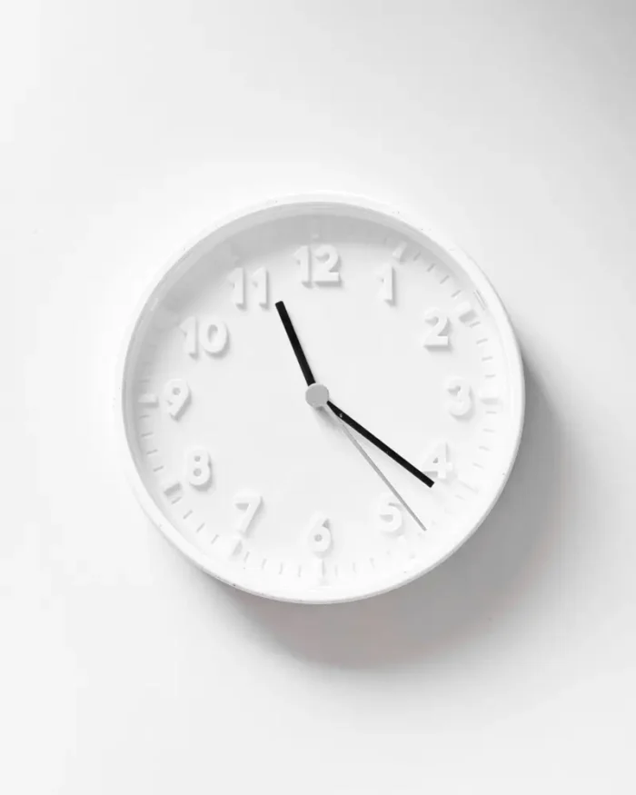 Close-up of the Halo minimal wall clock with a clean white dial and slim black hands