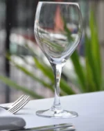 Lumière crystal wine glass on a fine dining table with white linen and silver cutlery