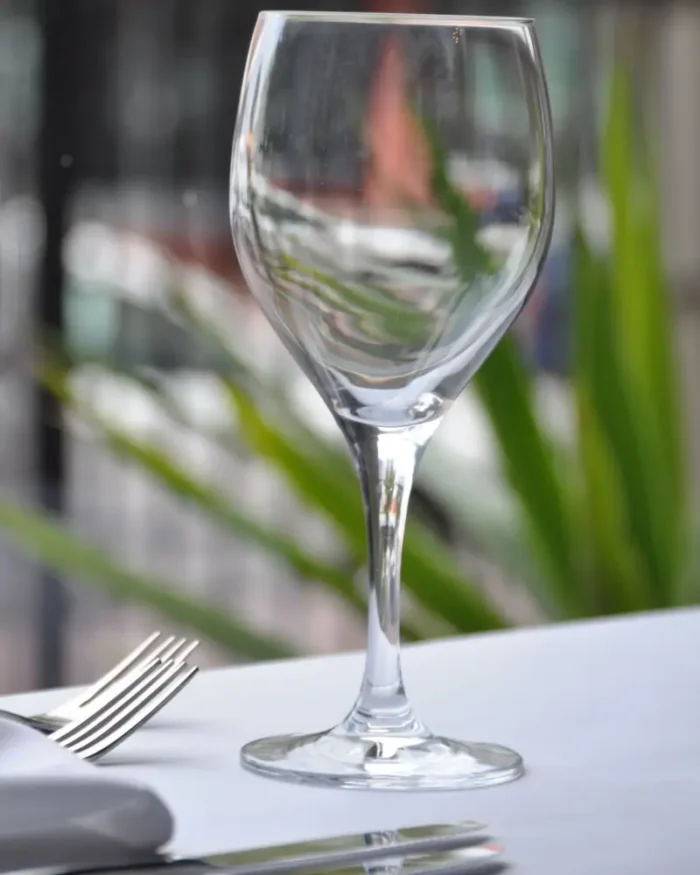 Lumière crystal wine glass on a fine dining table with white linen and silver cutlery