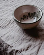 Terra stoneware bowl with a soft speckled glaze on crumpled grey linen