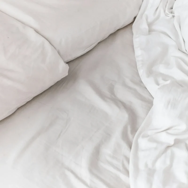 Soft drape and fold of white sateen bed linen